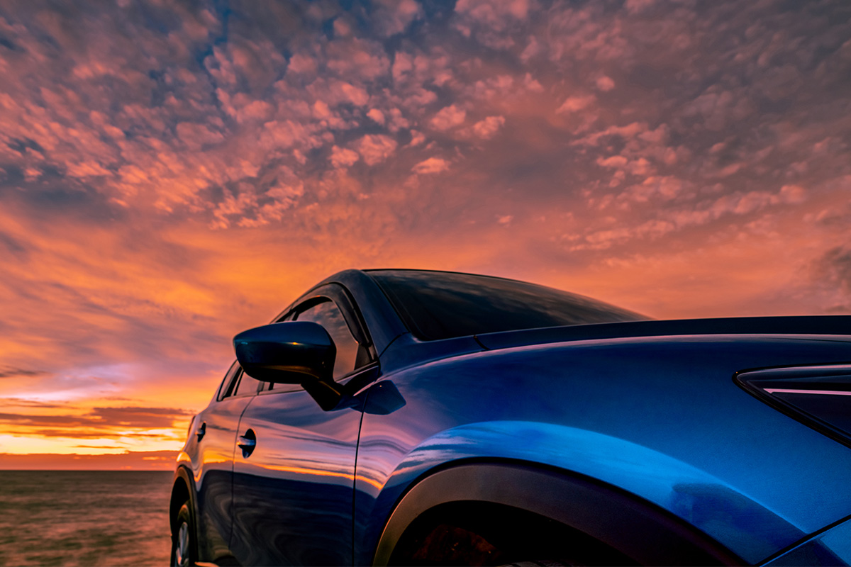 blue-compact-suv-car-with-sport-modern-luxury-design-parked-concrete-road-by-sea-sunset-travel-vacation-beach